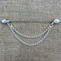 Lange versilberte Tuchnadel mit hängender Kette und Eicheln