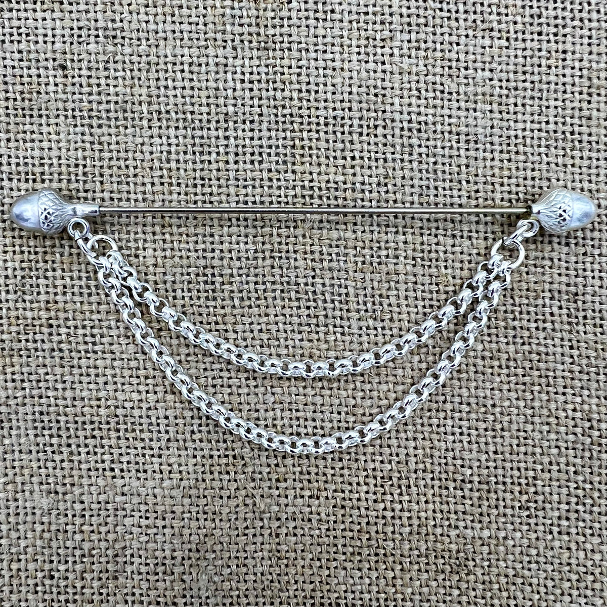 Lange versilberte Tuchnadel mit hängender Kette und Eicheln