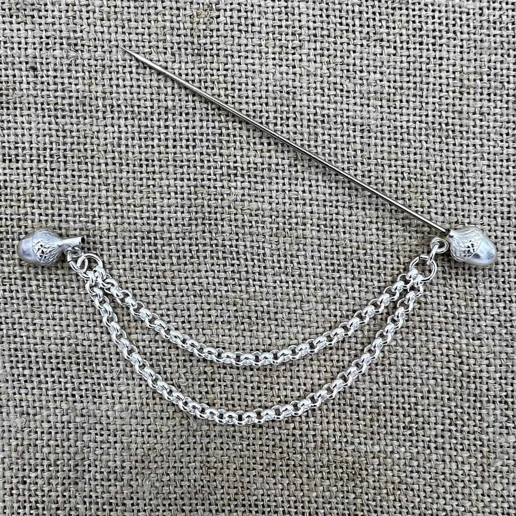 Lange versilberte Tuchnadel mit hängender Kette und Eicheln