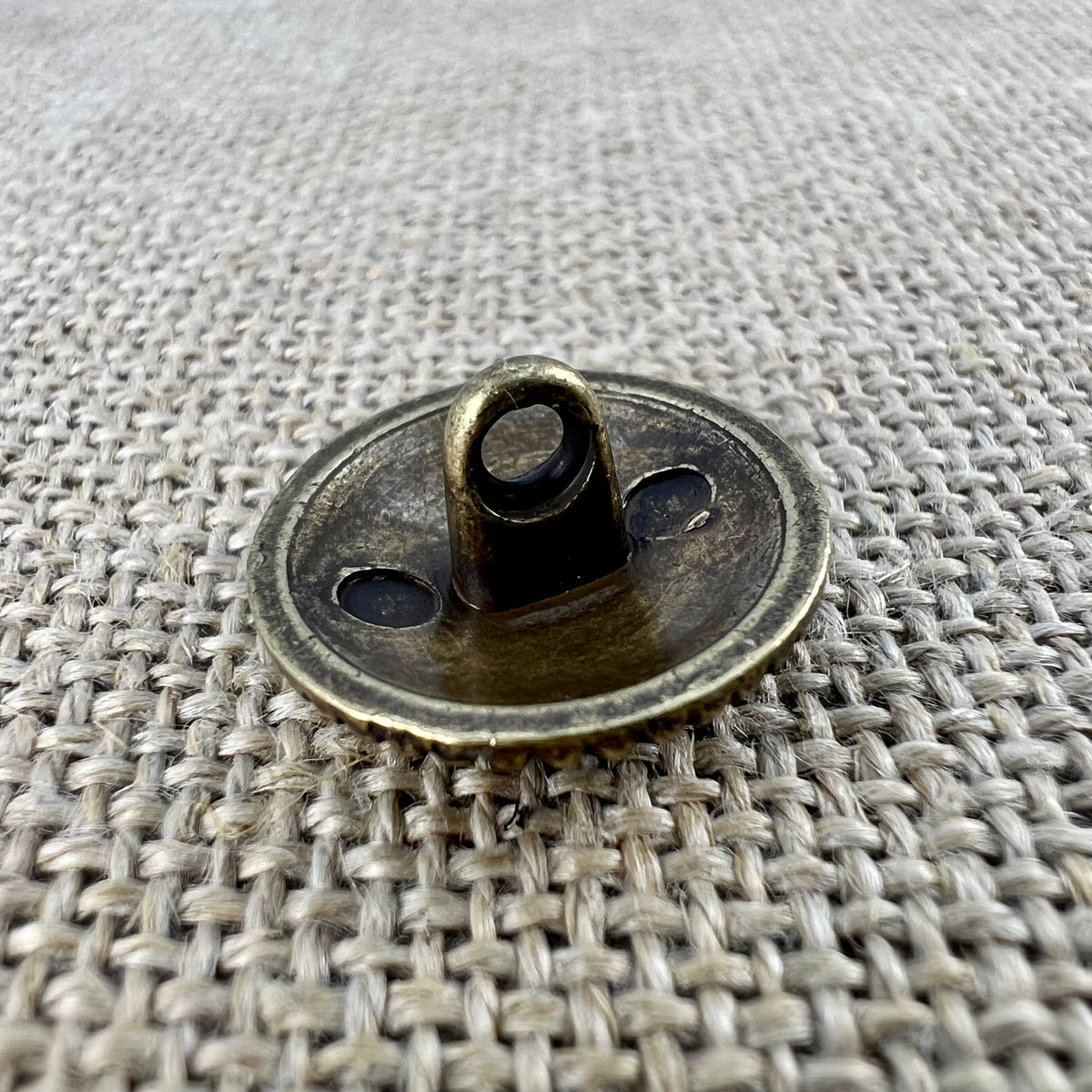Filigraner Messingknopf in Altgold mit Blume in der Mitte und Ranken