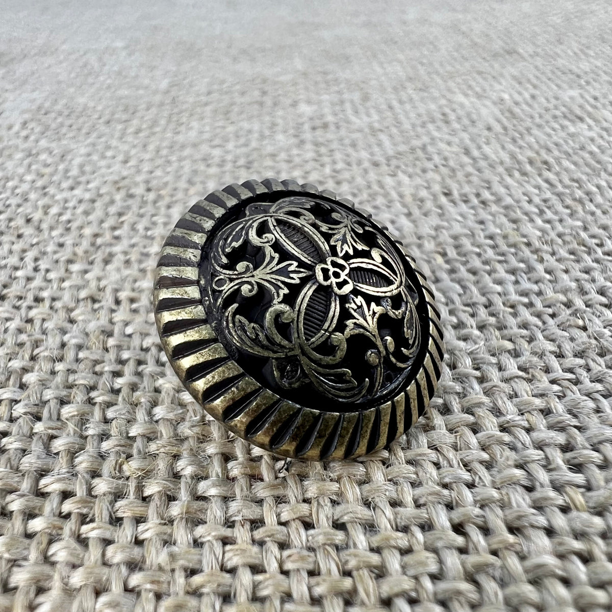 Filigraner Messingknopf in Altgold mit Blume in der Mitte und Ranken