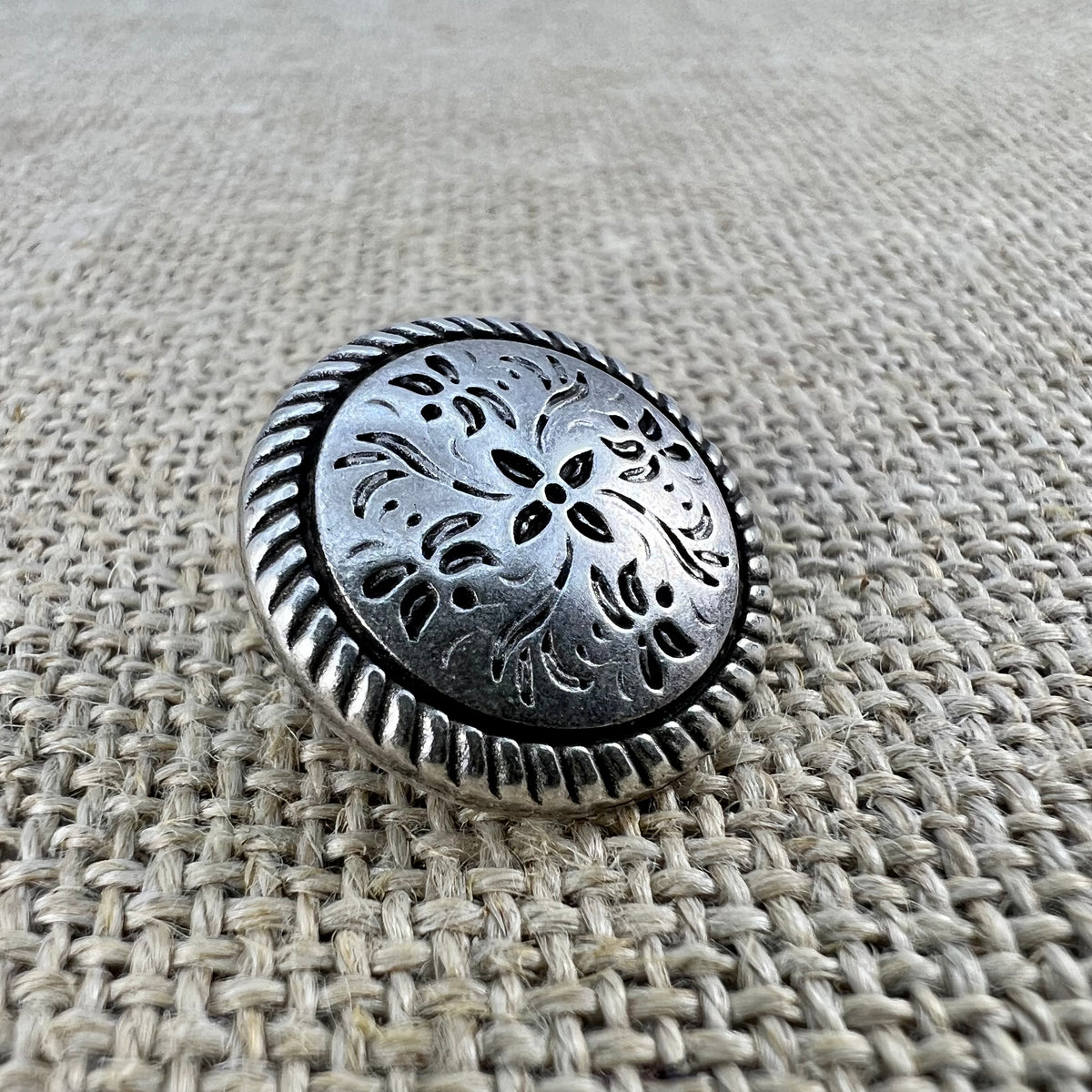 Floraler Messingknopf in Altsilber mit Blumenornamenten und filigranem Rand