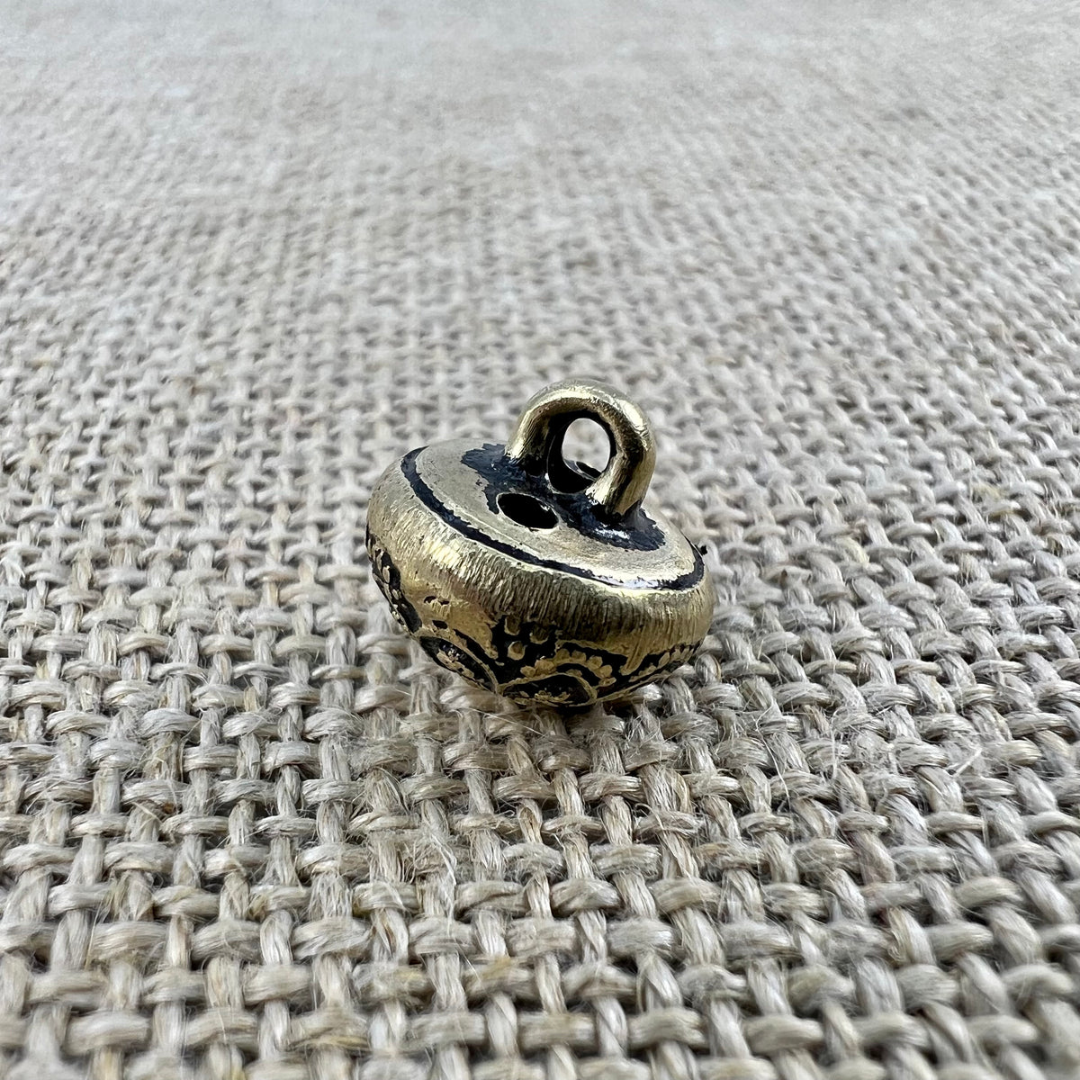 Antiker Metallknopf in Altmessing mit feinen Ornamenten, die in einer Kuppel zusammenlaufen