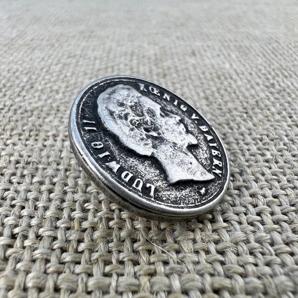 Runder Metallknopf in Altsilber mit dem Seitenprofil von König Ludwig II.