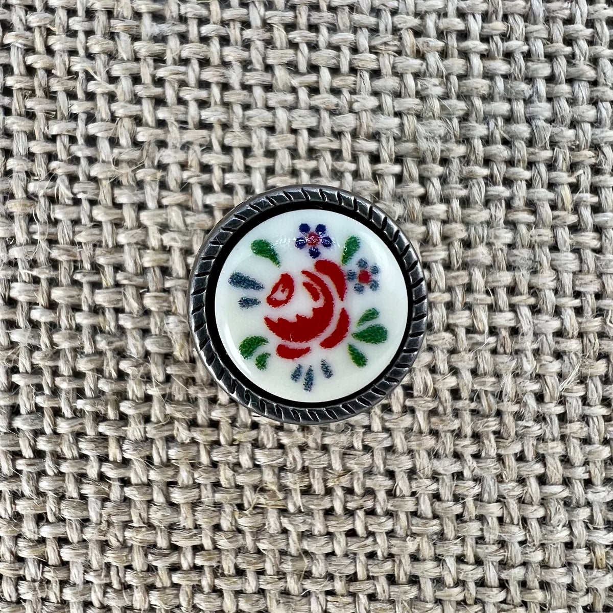 Trachtenknopf mit Blumeneinlage, Rose auf weißem Grund in Metallfassung
