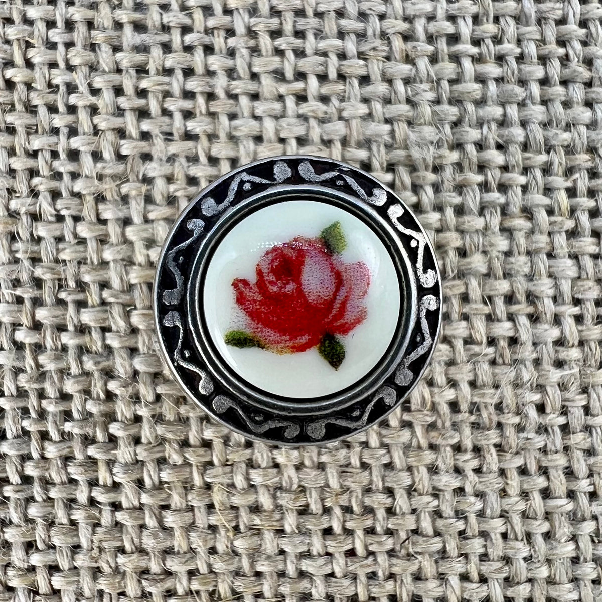 Metallknopf mit geprägtem Rand und Blumeneinlage, Rose als Motiv