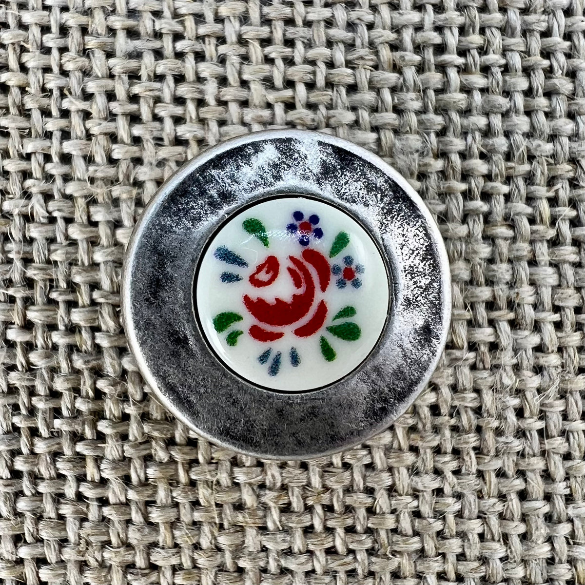 Rustikaler Metallknopf in Altsilber mit Blumeneinlage