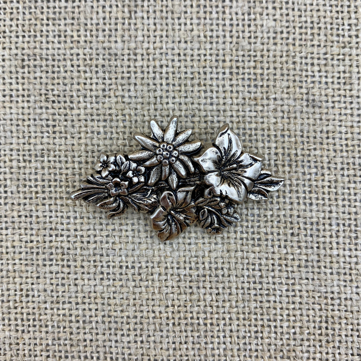 Anstecknadel in Altsilber mit Edelweiß auf einer Enzianblüte