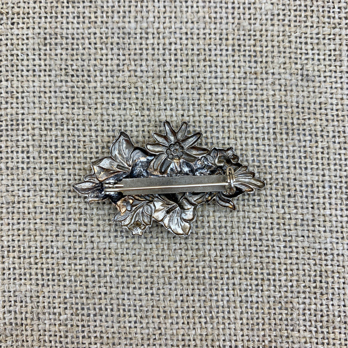 Anstecknadel in Altsilber mit Edelweiß auf einer Enzianblüte