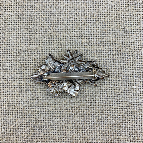 Anstecknadel in Altsilber mit Edelweiß auf einer Enzianblüte