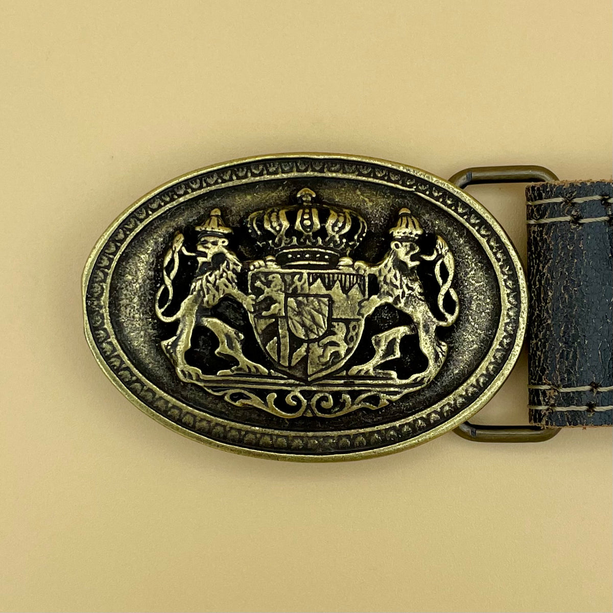 Schwarzer Ledergürtel mit ovaler Schnalle in Altmessing, Wappen zwischen zwei Löwen
