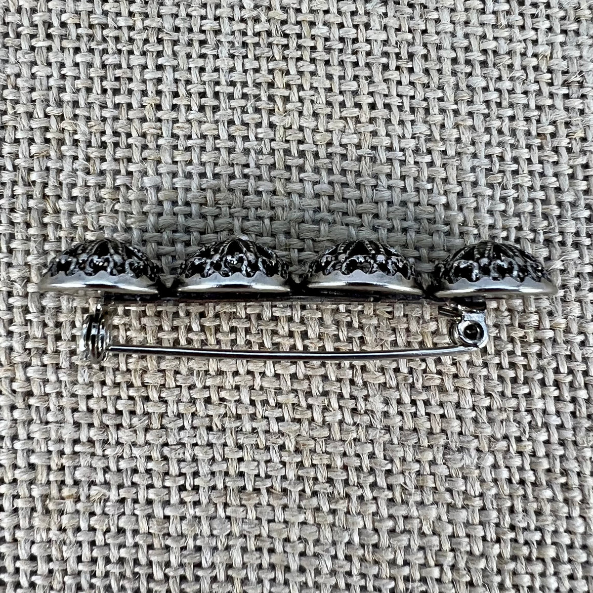 Anstecknadel mit vier filigranen Halbkugeln in Altsilber, in Sternform angeordnet