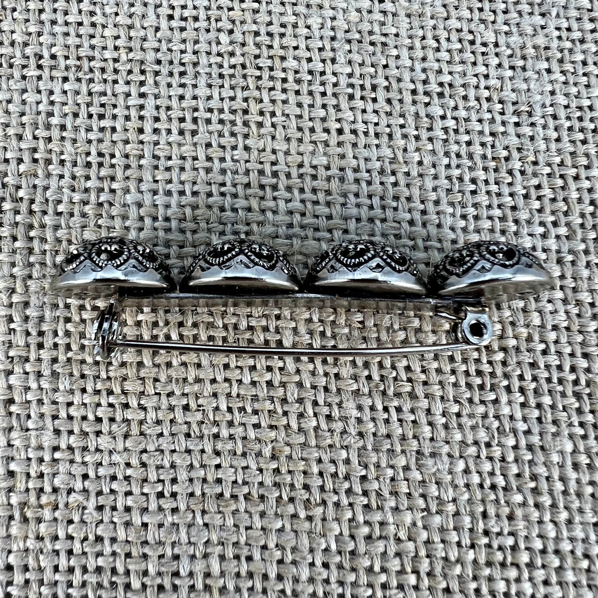 Anstecknadel mit vier filigranen Halbkugeln mit Blumenmuster in Altsilber