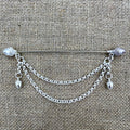Lange versilberte Tuchnadel mit Kette und Eicheln