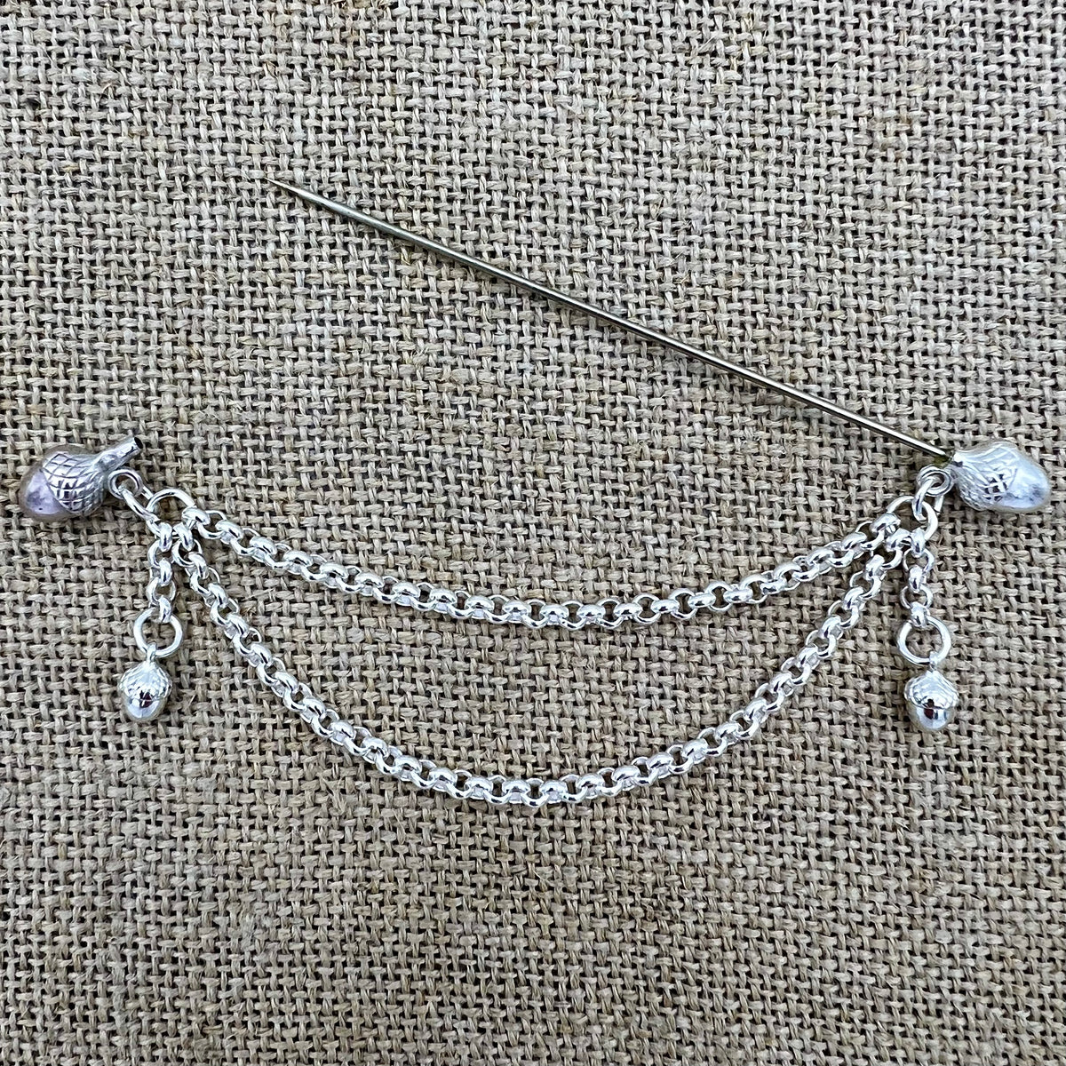 Lange versilberte Tuchnadel mit Kette und Eicheln