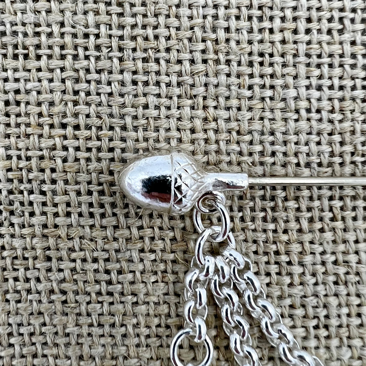 Lange versilberte Tuchnadel mit Kette und Eicheln