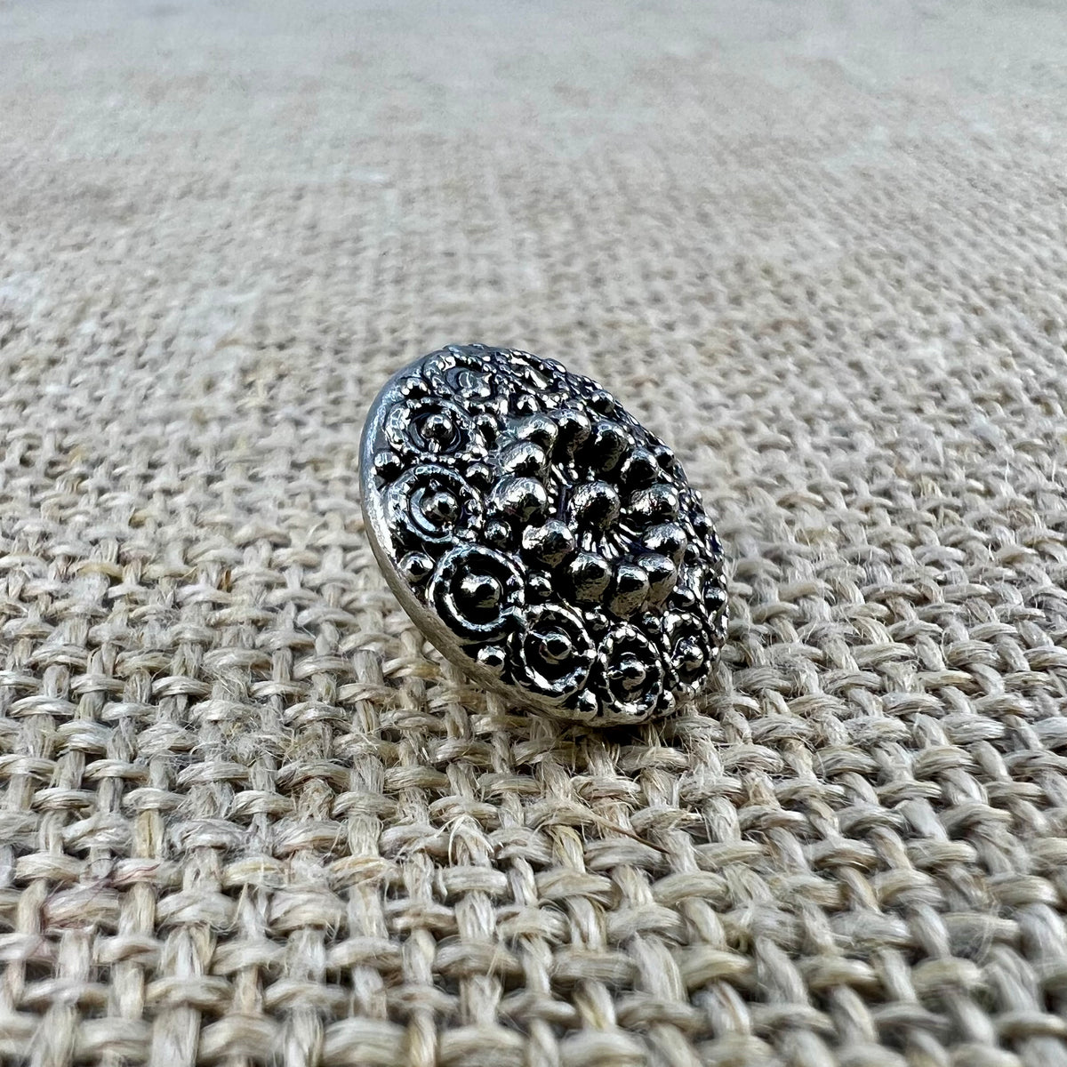 Runder filigraner Knopf aus Metall in Altsilber