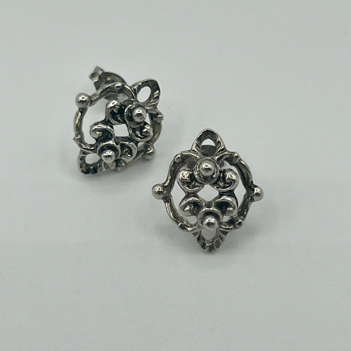 Silberfarbene Ornament-Ohrstecker mit filigraner, durchbrochener Rosette