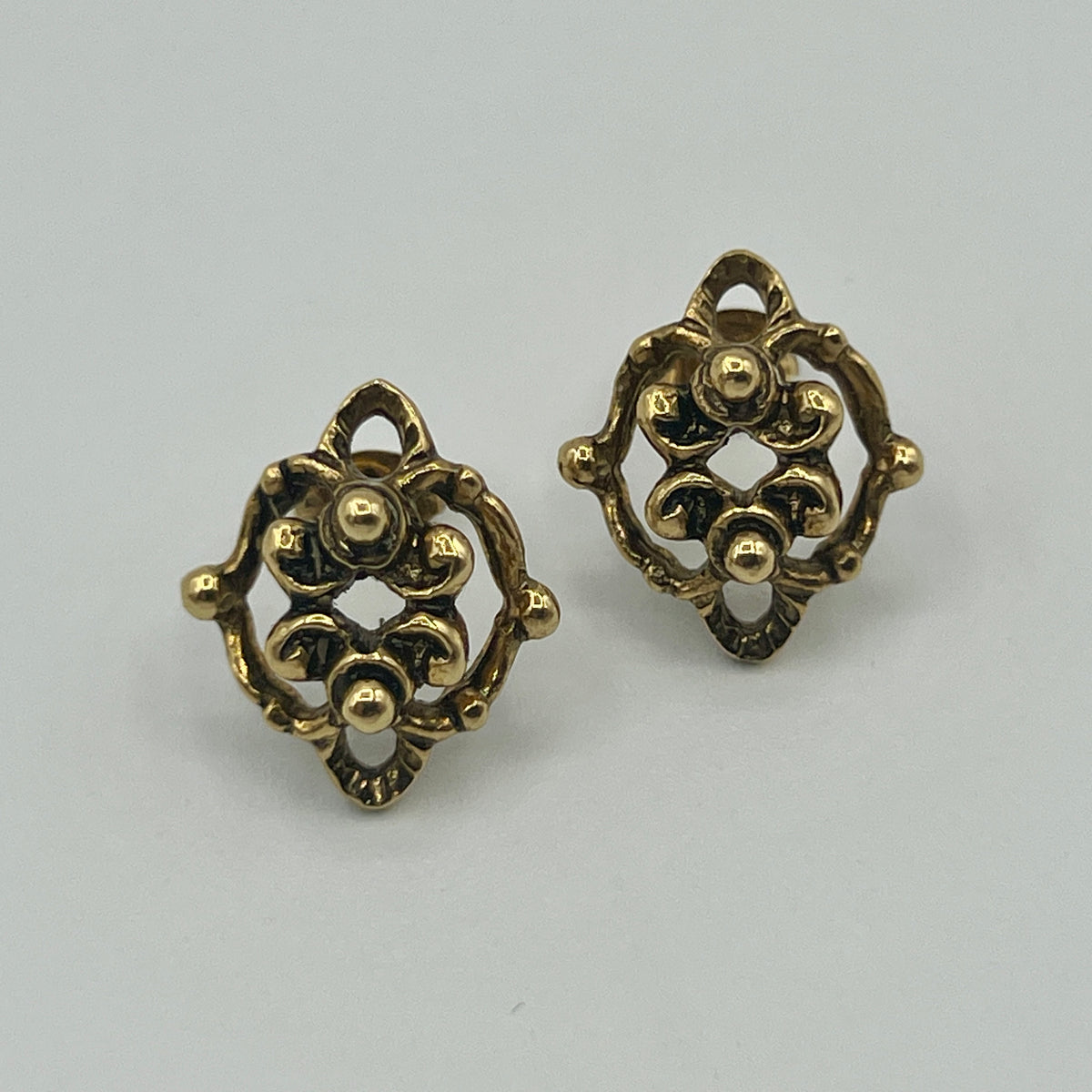 Goldfarbene Ornament-Ohrstecker mit filigraner, durchbrochener Rosette