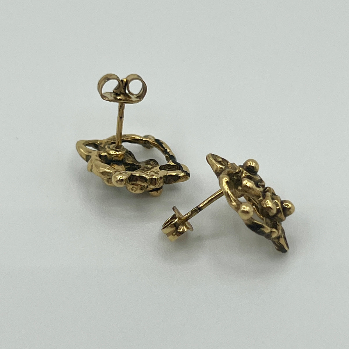 Goldfarbene Ornament-Ohrstecker mit filigraner, durchbrochener Rosette