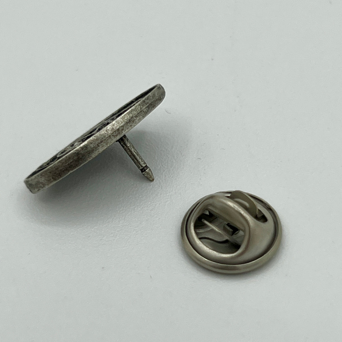 Kleine ovale Anstecknadel mit Notenschlüssel auf schwarzem Grund im Antik-Silber-Look