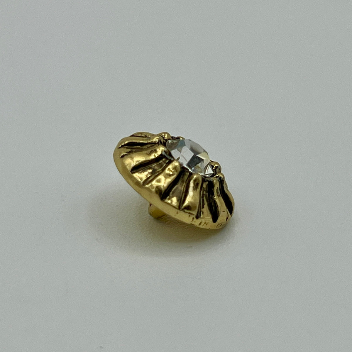 Zierknopf in Goldoptik mit facettiertem Kristallstein in geriffelter Fassung