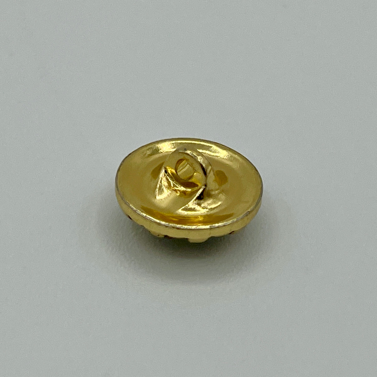 Zierknopf in Goldoptik mit facettiertem Kristallstein in geriffelter Fassung